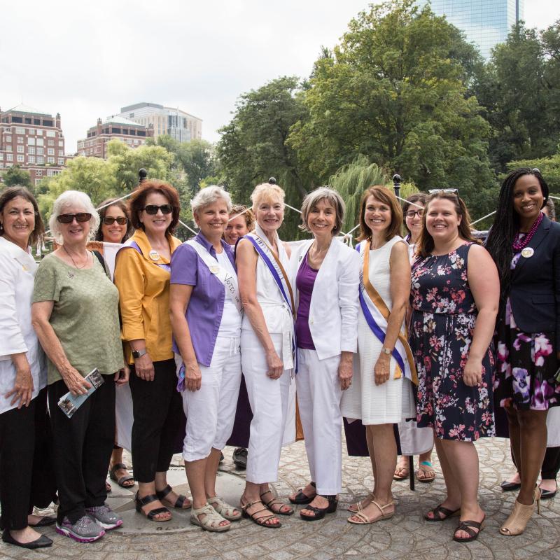 Twelve women stand outside smiling.