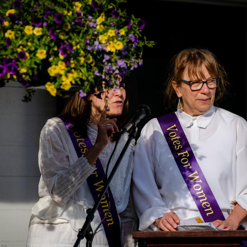 Woman stands at podium speaking.