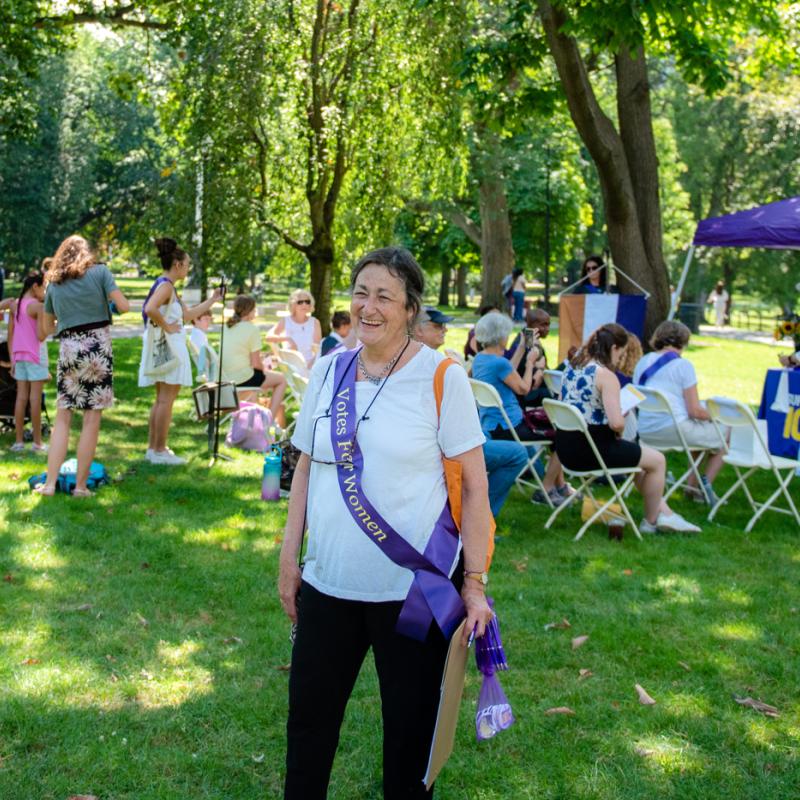 Woman outside wearing purple sash.