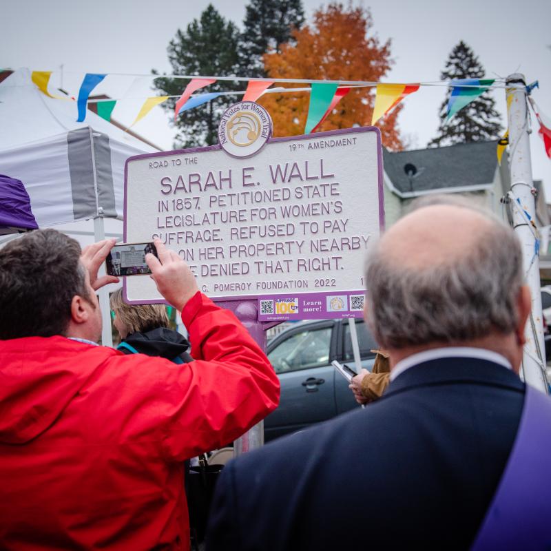 Two people look at sign.