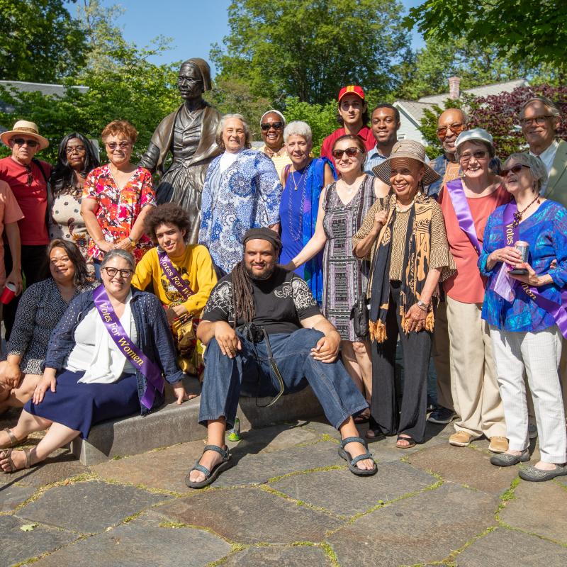 Group of adults stand outside smiling.