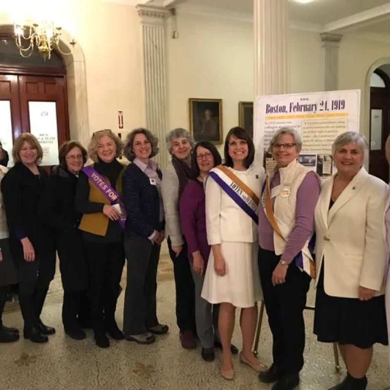 Large group stands smiling at camera.