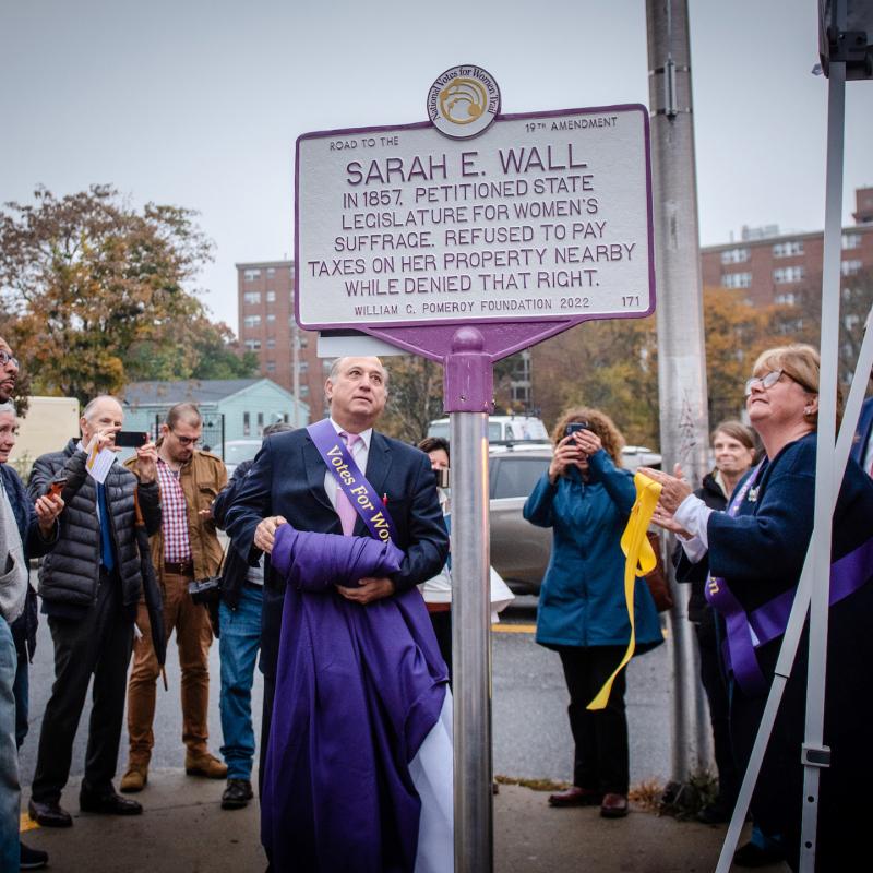 Group looks at Sarah E. Wall suffrage marker.