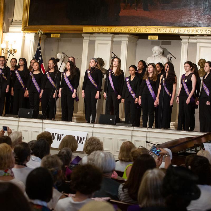 Group of teenagers sing on stage.