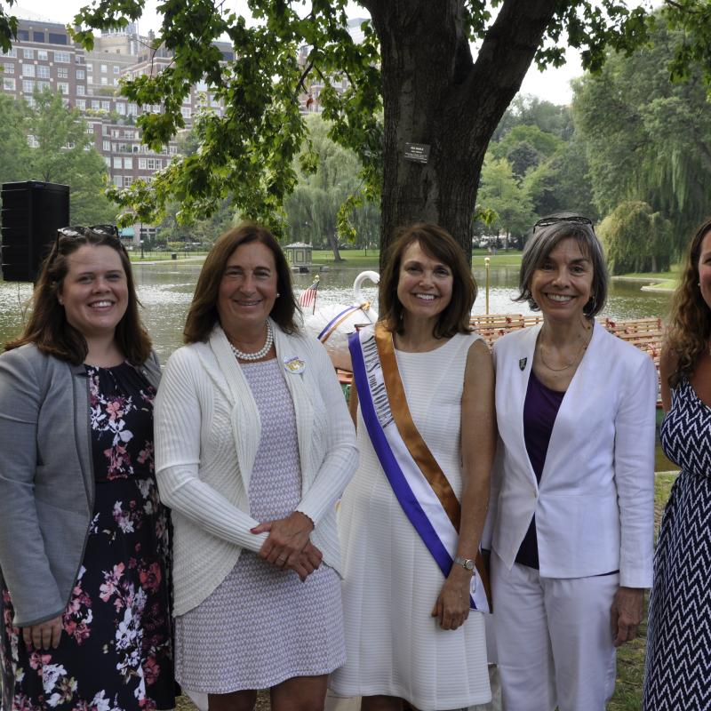 Five women stand outside smiling.