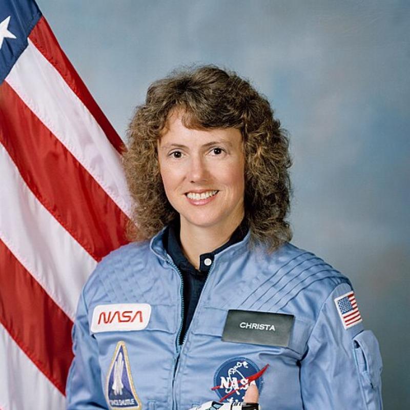 Portrait of a woman posing in a uniform in front of an American flag