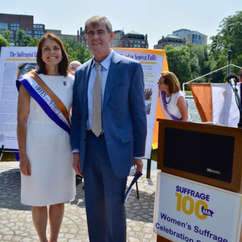 Two adults stand outside smiling.