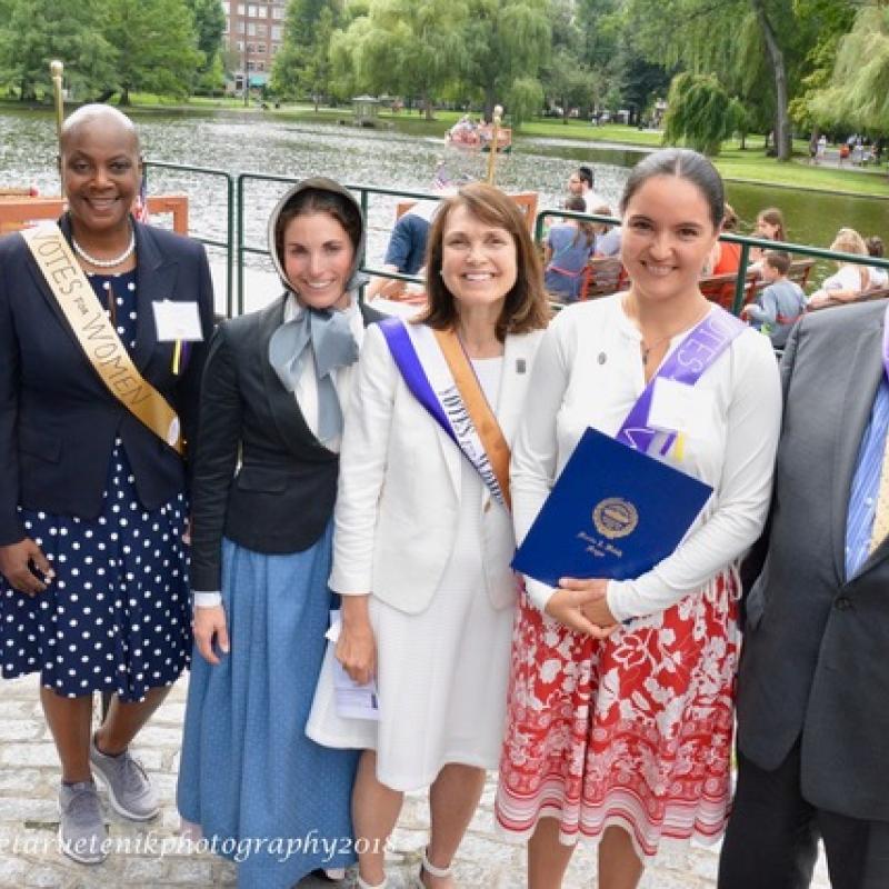 Six adults wearing sashes smiling.