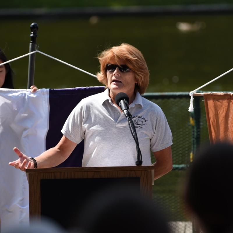 Woman stands at podium speaking.