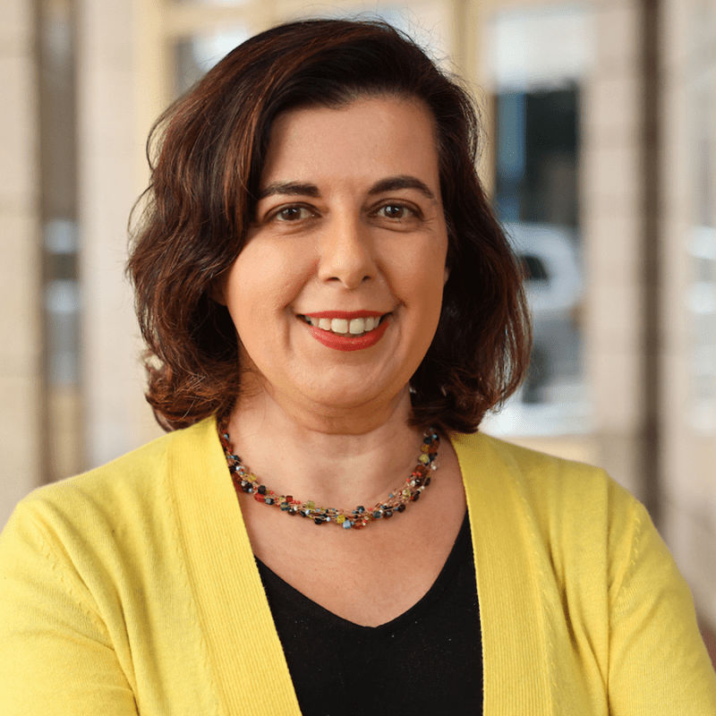 headshot of Laura Prieto wearing a yellow sweater and smiling