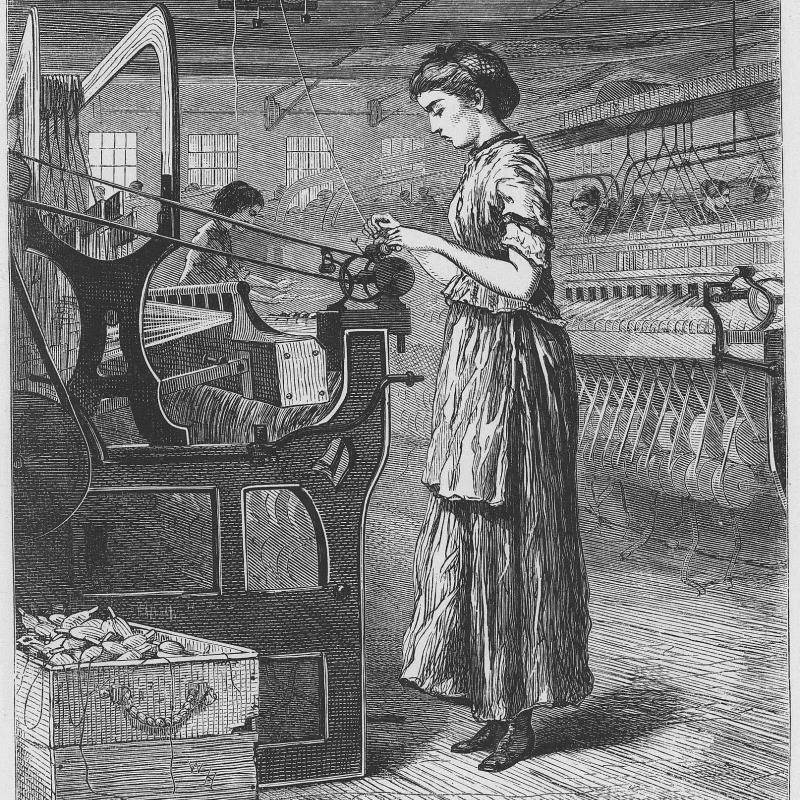 woman standing and using a piece of factory equipment