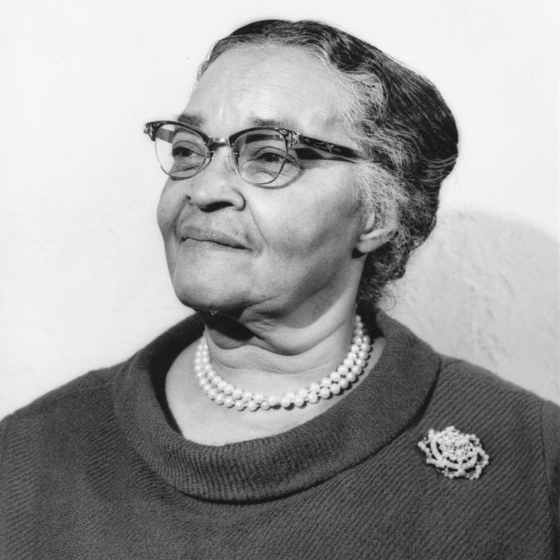 older woman with glasses and a pearl necklace