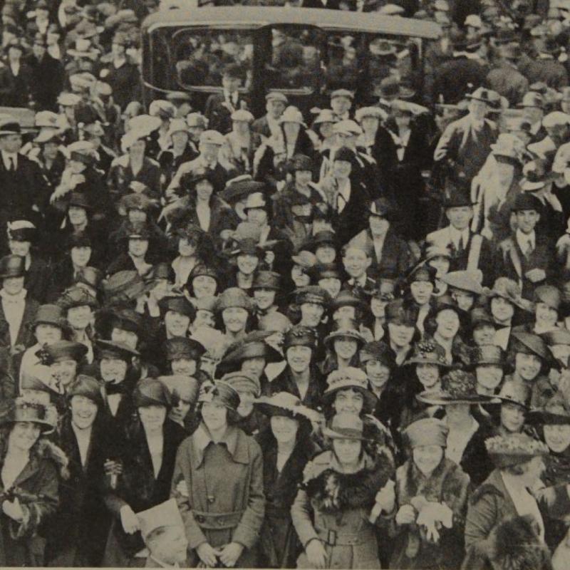 Vintage black and white photograph of large crowd of men and women outside.