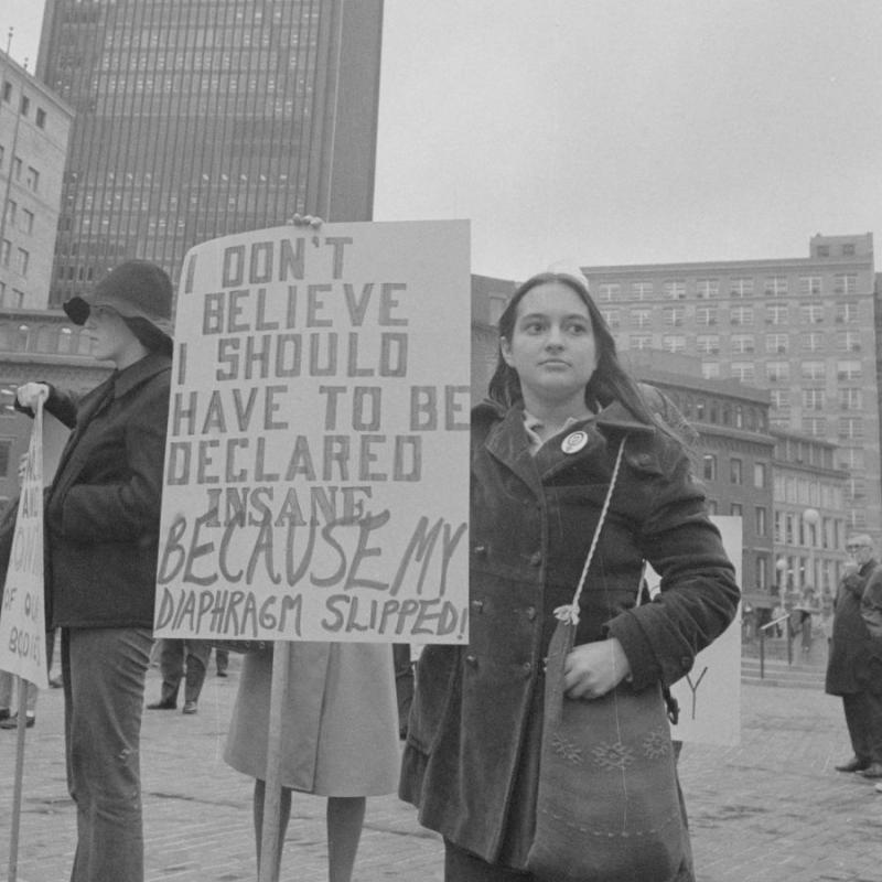 Woman holding a sign at a protest in the 1970s
