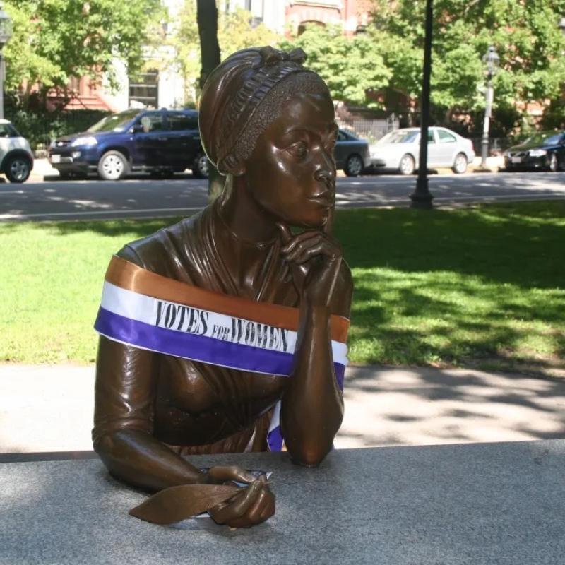 Statue of woman wearing sash.