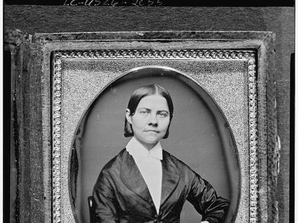 Half-length daguerreotype portrait of a Lucy Stone seated, facing front.