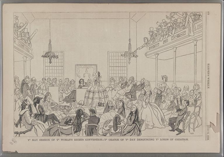 Print shows a group of women in a hall listening to a woman speaker who is pointing to the men sitting in an upper gallery. 
