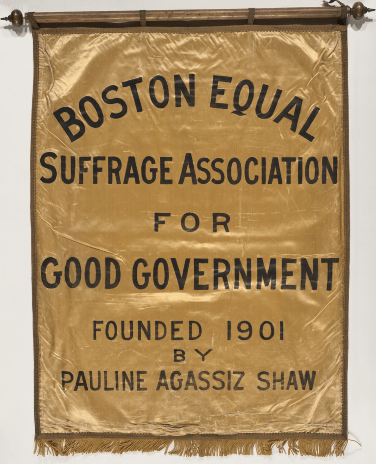 Gold banner with tassels that reads "Boston Equal Suffrage Association for Good Government, Founded 1901 by Pauline Agassiz Shaw"