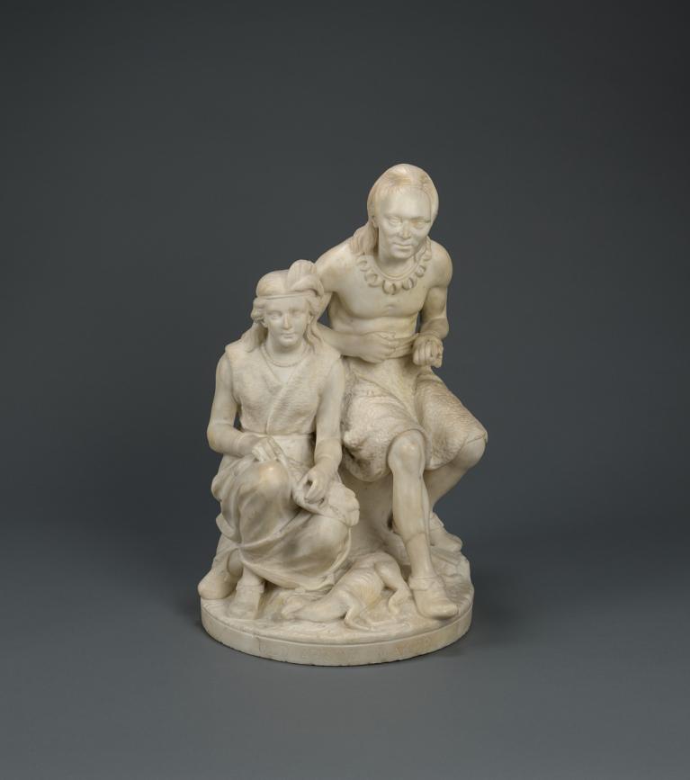 Marble sculpture of Minnehaha (of the Dakota tribe) seated next to her father. They are both looking up to greet Hiawatha, an Ojibwe woman.