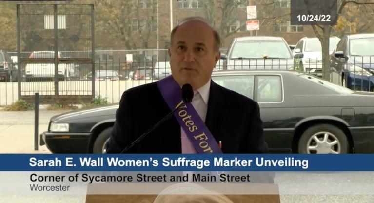 Man stands at podium speaking.