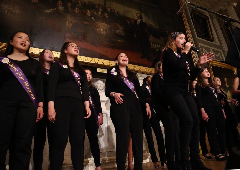 Girls sing on stage.