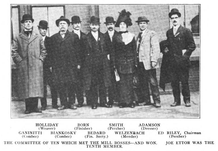 Black and white photo of eight men and one woman.