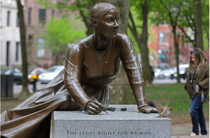 Statue of a woman sitting on a stone block