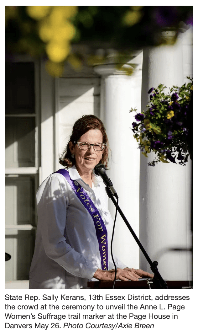 Woman stands at podium speaking.